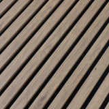 Close-up of the white wood veneer grain and evenly spaced black gaps between acoustic slats