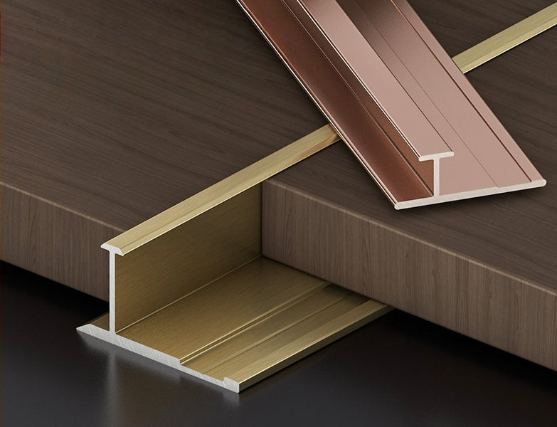 Gold and rose-gold aluminum H-joint trims displayed with dark wood-look wall panels