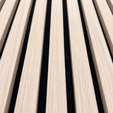 Close-up of natural oak acoustic slat wall panel with black felt backing