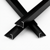 Three black aluminum alloy end cap trim pieces arranged in a crossed display