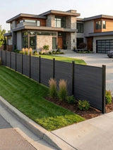 Black composite fence installed along the front lawn of a modern home