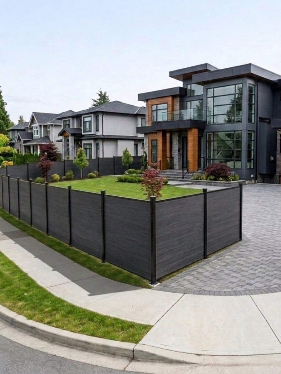 Black composite fence enclosing the corner yard and driveway of a modern house