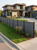 Light gray composite privacy fence bordering the lawn of a modern two-story home