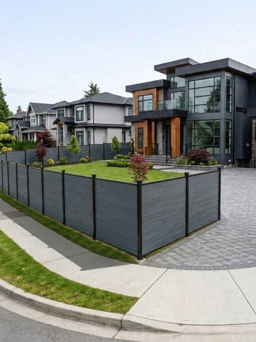 Light gray composite fence enclosing the corner lawn of a modern home
