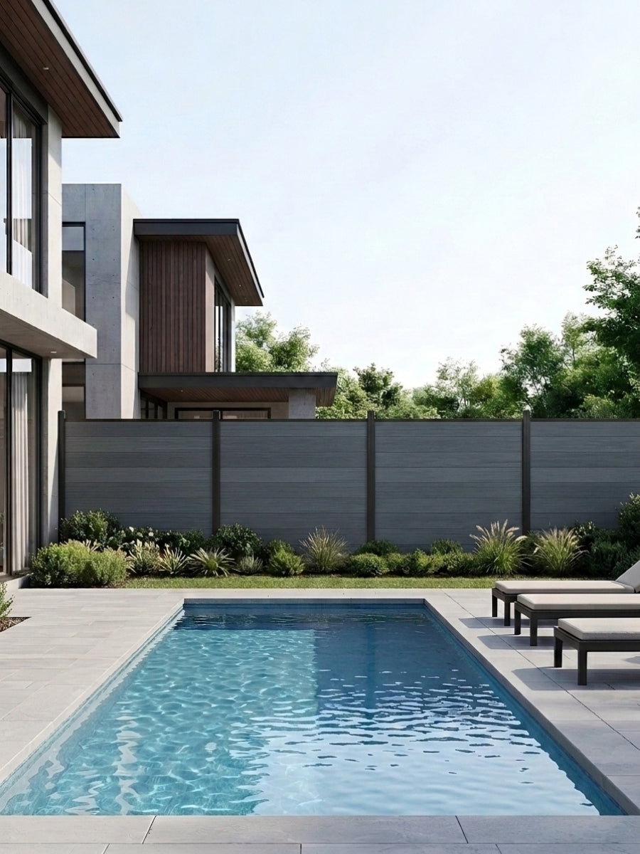 Light gray composite privacy fence installed behind a modern backyard swimming pool