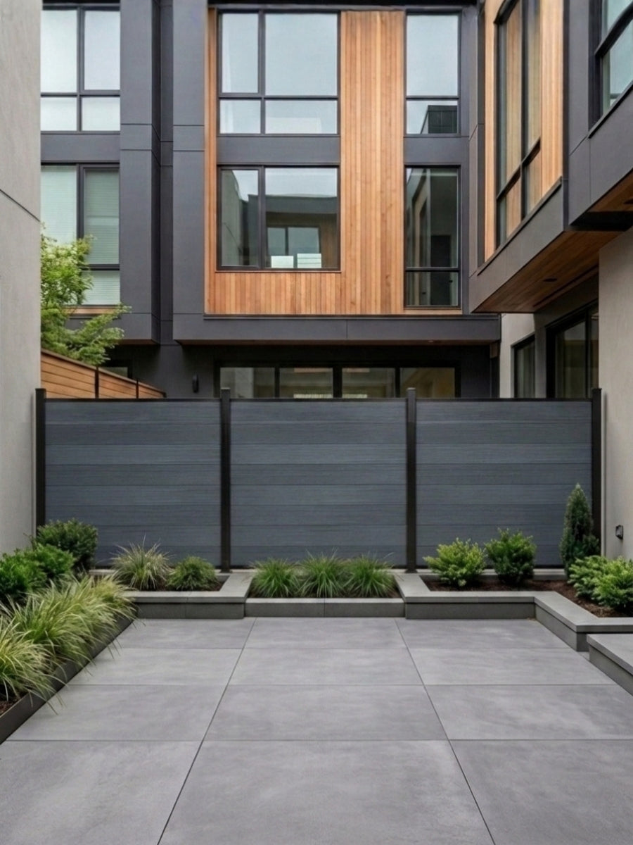Light gray composite privacy fence installed across a modern paved courtyard garden