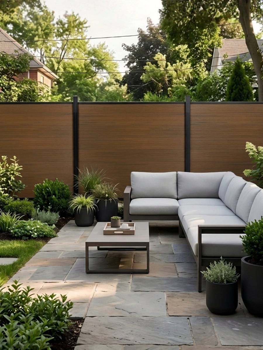 Walnut composite fence surrounding a garden patio with sectional sofa and potted plants