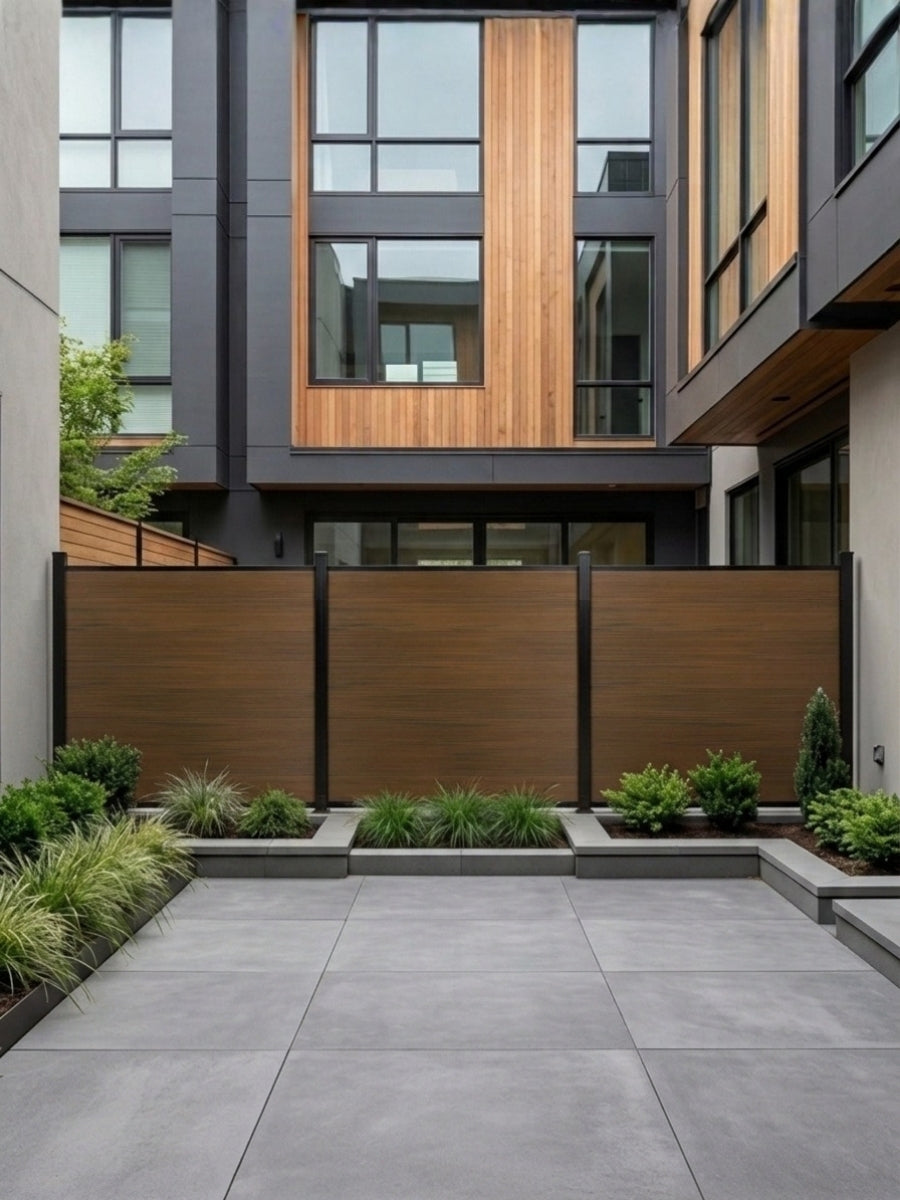 Walnut composite privacy fence installed in a modern courtyard with raised garden beds