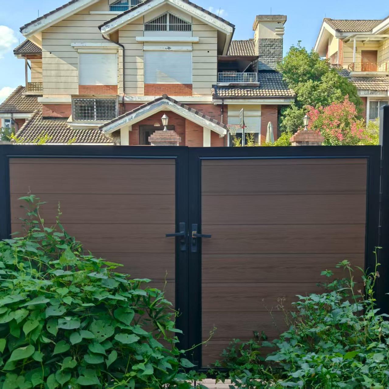 Brown Composite double gate with black frame in front of a house.