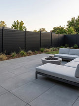 Black full privacy fence enclosing a contemporary patio with outdoor seating and a fire pit