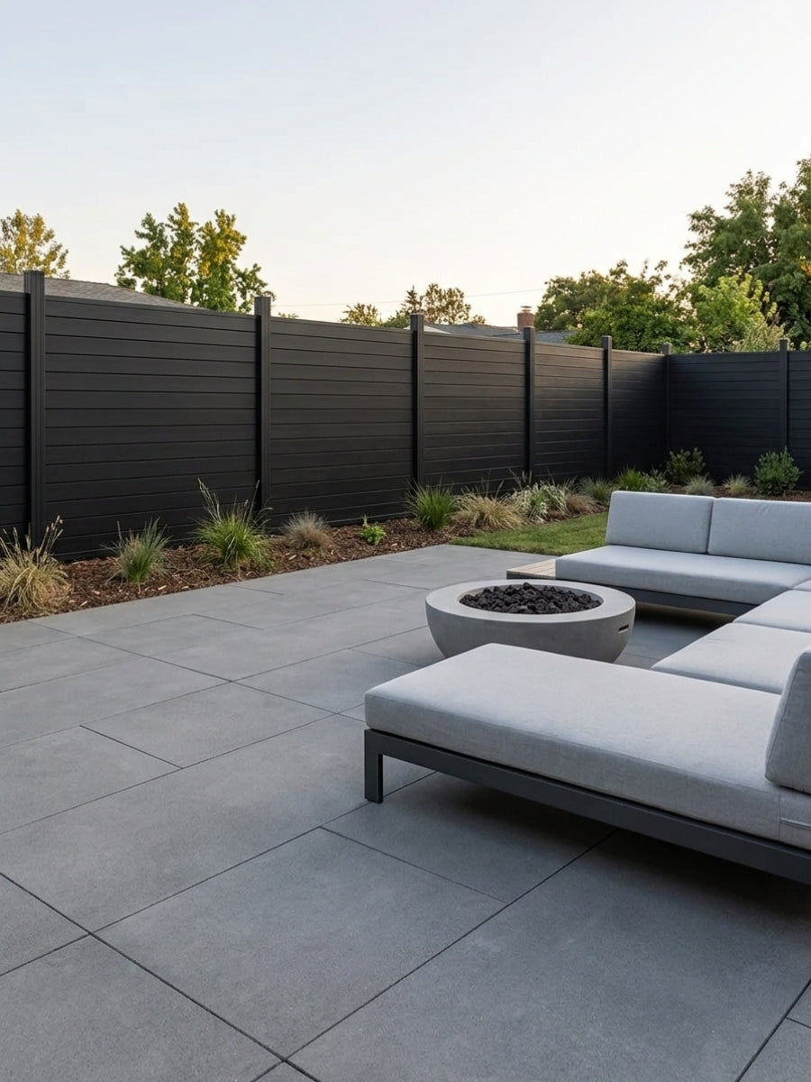 Black full privacy fence enclosing a contemporary patio with outdoor seating and a fire pit