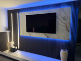 Modern interior design with a TV mounted on a PVC Marble Sheet, illuminated by LED lights inside Acoustic Wall Panels