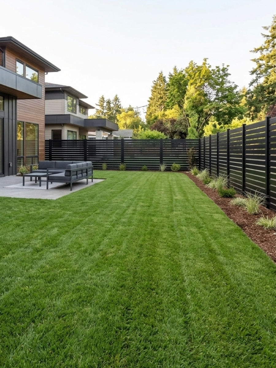 Black aluminum semi privacy fence enclosing a modern backyard with lawn and patio seating