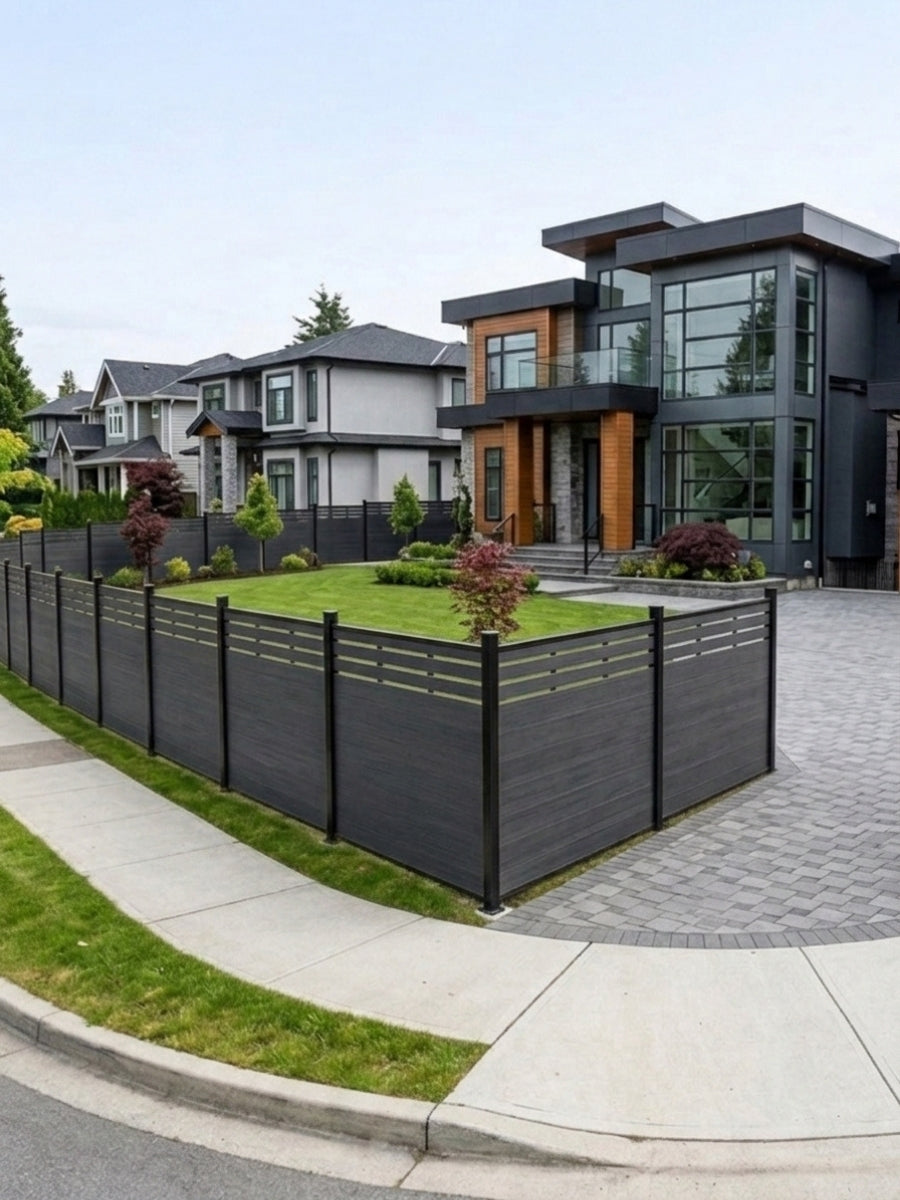 Black composite privacy fence enclosing the corner lawn and driveway of a modern house