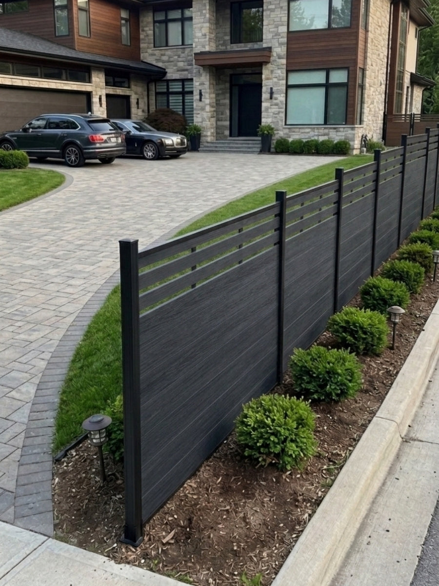 Angled view of a composite lattice-top fence installed beside shrubs and a paved driveway