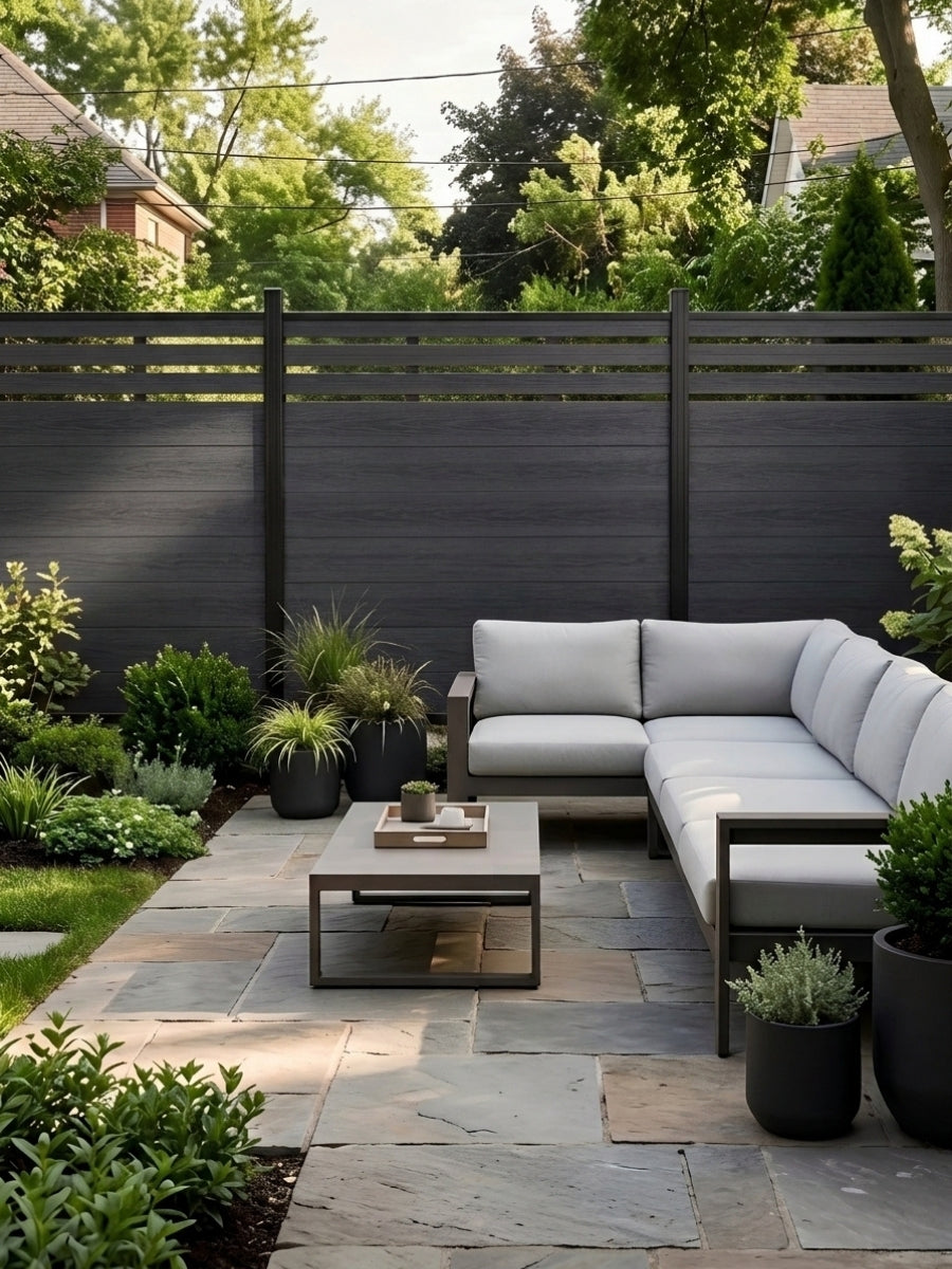 Black top lattice privacy composite fence bordering a garden patio with sectional sofa and coffee table