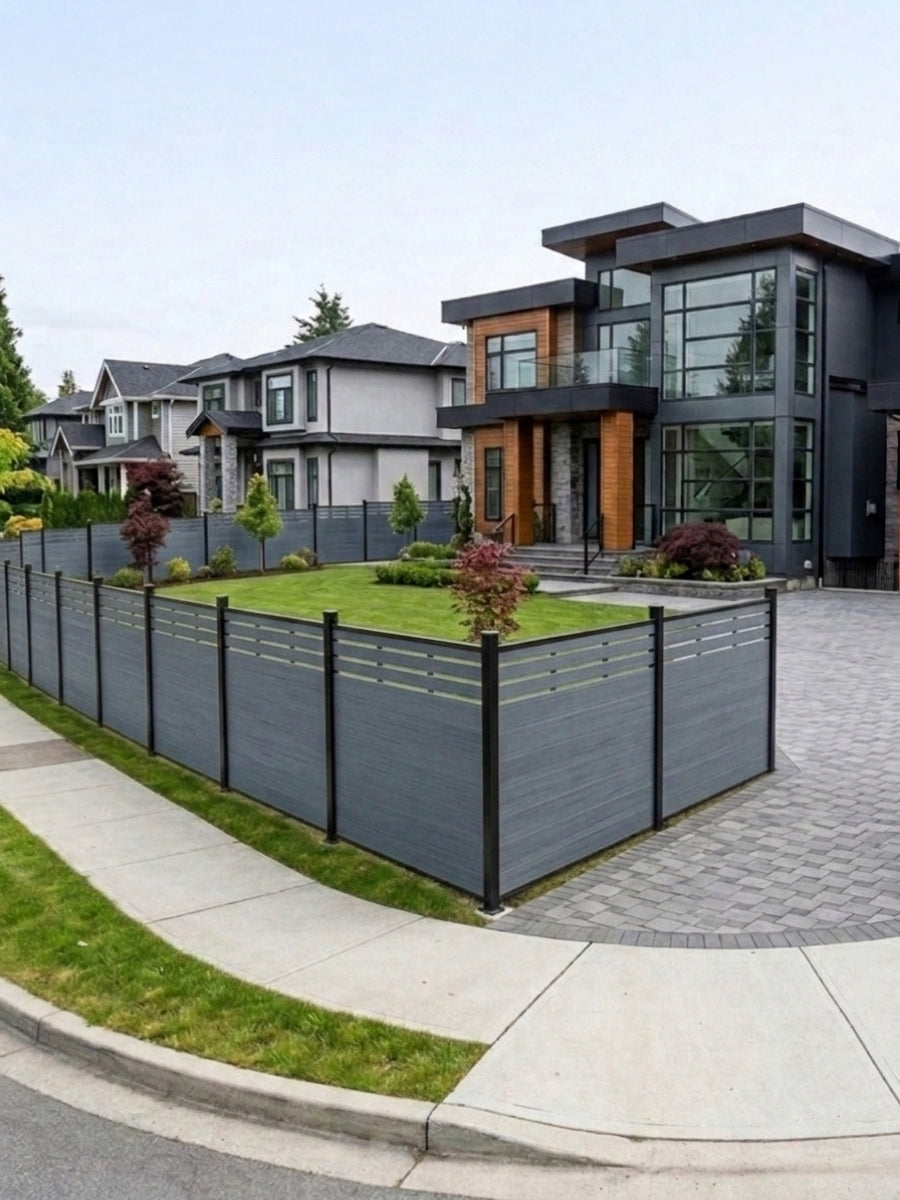 Light gray composite privacy fence enclosing a corner lot with lawn and modern house