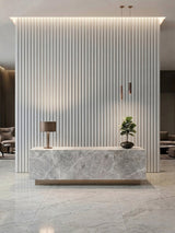 White brushed WPC fluted 3D wall panels behind a marble-look reception desk with pendant lights