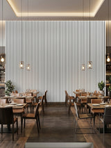 Floor-to-ceiling white brushed WPC fluted wall panels forming a feature wall in a restaurant dining area