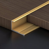 Gold 3mm aluminum end cap trim fitted along the edge of a dark wood-look PVC wall panel
