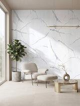 White Gray Pearl Marble PVC feature wall behind a cream lounge chair, ottoman, potted tree, and round table.