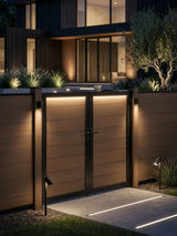 WPC Fence Gate Double 6ft x 6ft with brown wood-grain panels and black frame, installed in an illuminated modern privacy fence at night.