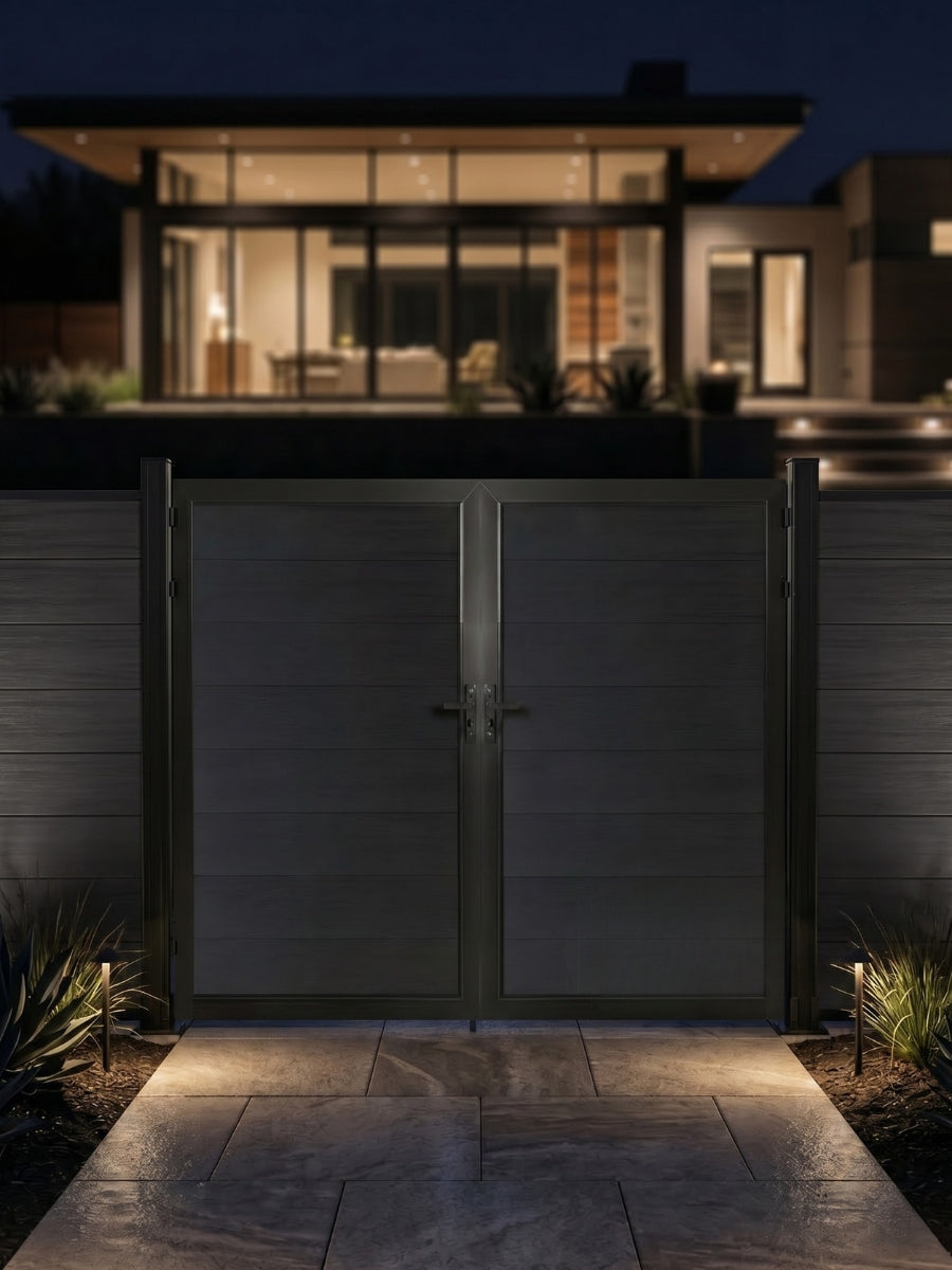 8ft x 6ft black WPC double fence gate with horizontal panels installed outside a modern home with landscape lighting