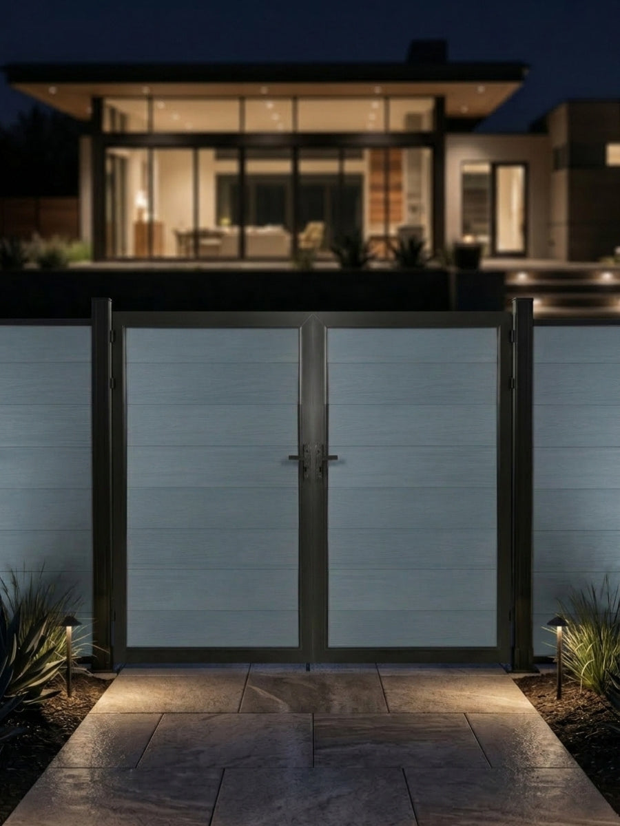 8ft x 6ft gray WPC double fence gate with black frame illuminated along a walkway outside a modern home at night